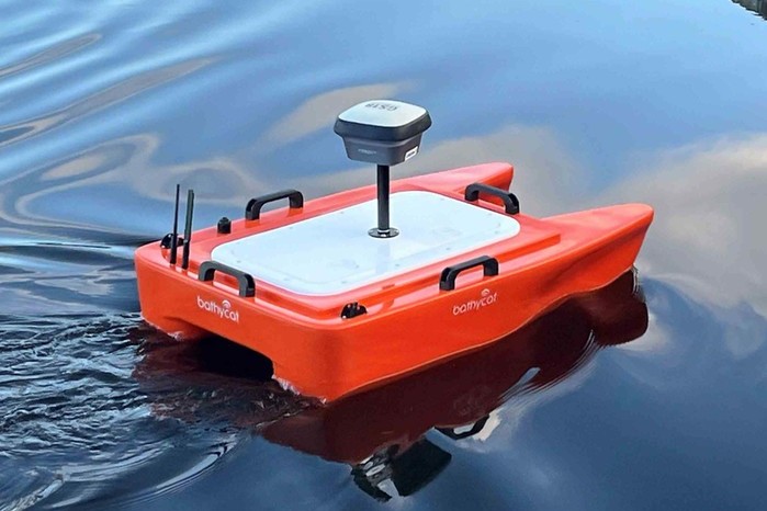 Uncrewed survey vessel with GNSS antenna on calm water