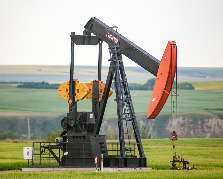 Pumpjack on a well site surrounded by cultivated prairie farmland